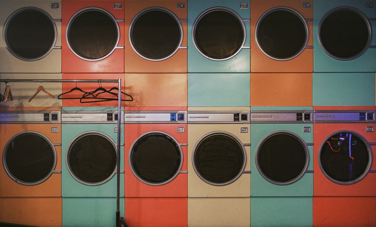 services-02 Colorful row of vintage laundry machines with hangers in a laundromat.